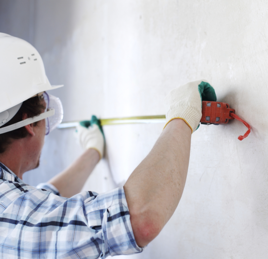 Contractor Measuring A Wall